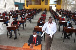 An invigilator distributing examination papers in an exam room