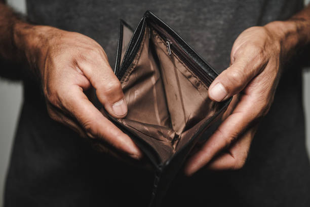 A Close up picture of a man's hands holding and empty wallet.